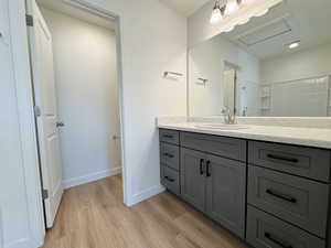 Full bath featuring vanity and light wood-type flooring