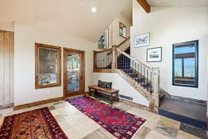 Entryway with high vaulted ceiling, plenty of natural light, recessed lighting, and stairs