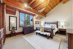Bedroom featuring wooden ceiling, light colored carpet, and track lighting