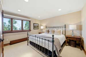 Bedroom with light colored carpet, recessed lighting, and a baseboard radiator