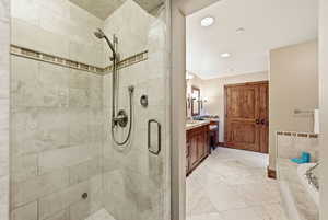 Bathroom featuring vanity, recessed lighting, a bath, light tile patterned floors, and a shower stall