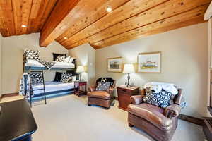 Carpeted bedroom featuring baseboards and wooden ceiling