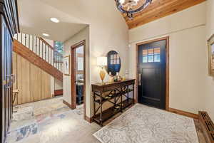 Foyer entrance with a baseboard radiator, plenty of natural light, recessed lighting, lofted ceiling, and a chandelier