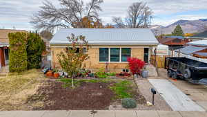 View of front of house featuring a metal roof, brick siding, and a mountain view