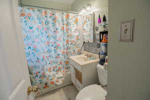 Bathroom featuring vanity and shower / tub combo with curtain