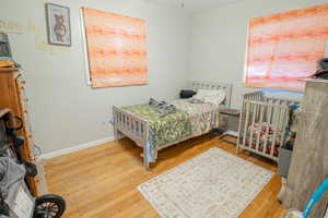 Bedroom with light wood-type flooring and baseboards