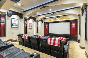 Home theater room with light carpet and ornamental molding