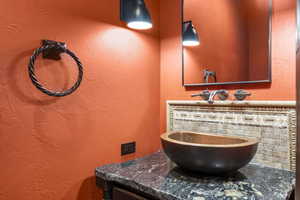 Bathroom with a textured wall and vanity