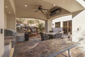View of patio with outdoor dining area, ceiling fan, and an outdoor kitchen