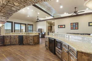 Kitchen with open floor plan, ceiling fan, recessed lighting, light stone countertops, and dark wood-type flooring