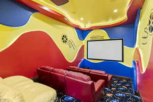 Cinema featuring a raised ceiling and recessed lighting