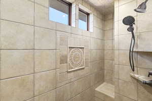 Full bath featuring a tile shower