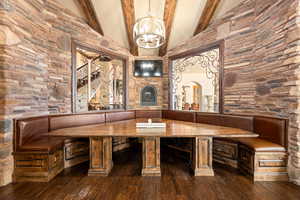 Wine room with hardwood / wood-style flooring, beamed ceiling, high vaulted ceiling, and a chandelier