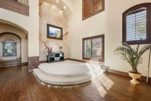 Entrance foyer featuring dark wood-type flooring, a high ceiling, and arched walkways