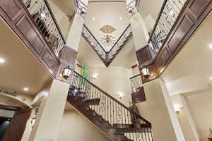 Staircase with a towering ceiling and recessed lighting