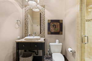Bathroom featuring vanity, a textured wall, and a tile shower