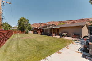 Fenced backyard featuring a patio and a view of the Moab Red Rocks.