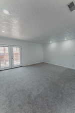 Primary bedroom, with carpet and French door access to private balcony.