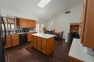 Kitchen featuring open shelves, light countertops, vaulted ceiling, pendant lighting, and brown cabinets