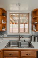 Kitchen featuring open shelves, light countertops, and healthy amount of natural light