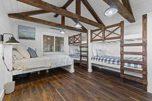 Bedroom featuring dark wood-style floors and wooden walls