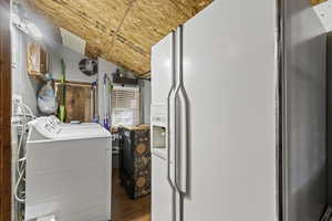 Washroom with lofted ceiling, dark wood-style floors, and washer and dryer