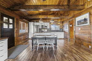 Dining space featuring wooden walls, wood ceiling, and dark wood finished floors