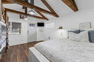 Bedroom with wood walls and dark wood-type flooring