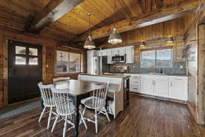 Dining room featuring dark wood-style flooring, wood walls, and wood ceiling