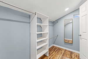 Walk in closet with light wood-type flooring