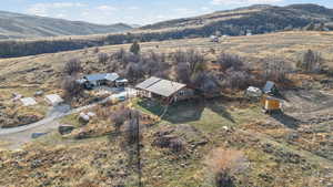 Aerial overview of property's location featuring a mountainous background and rural landscape