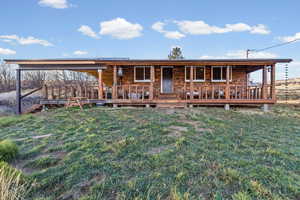 View of front of property with covered porch, a metal roof, and a front lawn