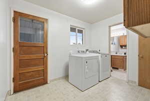 Laundry area with washer and clothes dryer and baseboards