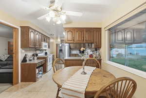 Dining space with ceiling fan and light tile patterned floors