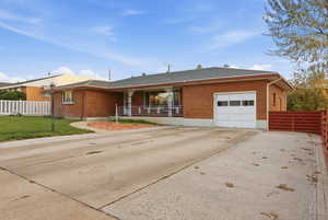Ranch-style house featuring concrete driveway, brick siding, a shingled roof, and an attached garage