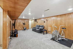 Exercise room with carpet and wooden walls