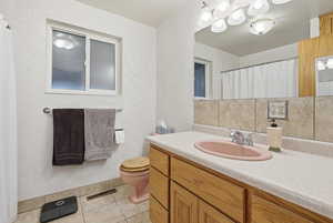 Bathroom with vanity, curtained shower, and light tile patterned floors