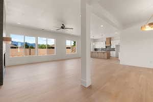Unfurnished living room featuring recessed lighting, light wood-style floors, a mountain view, and ceiling fan
