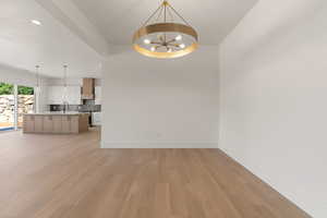 Unfurnished living room featuring recessed lighting, a chandelier, and light wood-type flooring