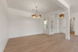 Unfurnished dining area with light wood finished floors and a chandelier