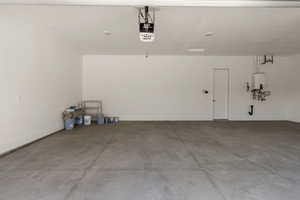 Garage featuring a garage door opener and water heater