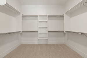 Walk in closet featuring light colored carpet