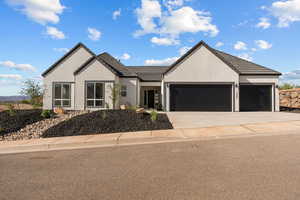 View of front of house featuring a garage, stucco siding, driveway, and a tiled roof