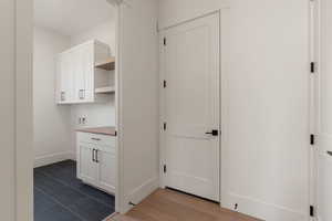 Washroom featuring cabinet space, hookup for a washing machine, and dark tile patterned flooring