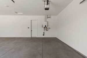 Garage featuring a garage door opener and baseboards
