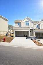 View of front of property with a garage and concrete driveway