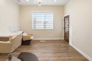 Sitting room with light wood-style flooring, recessed lighting, and a chandelier