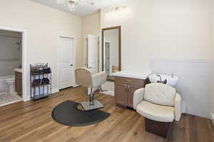 Bathroom featuring light wood-style floors, vanity, tile walls, shower / tub combination, and a chandelier