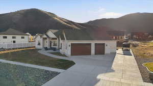 View of front of house with a garage, concrete driveway, and a mountain view