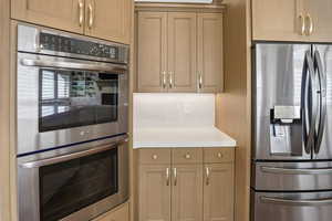 Kitchen featuring stainless steel appliances and light stone counters
